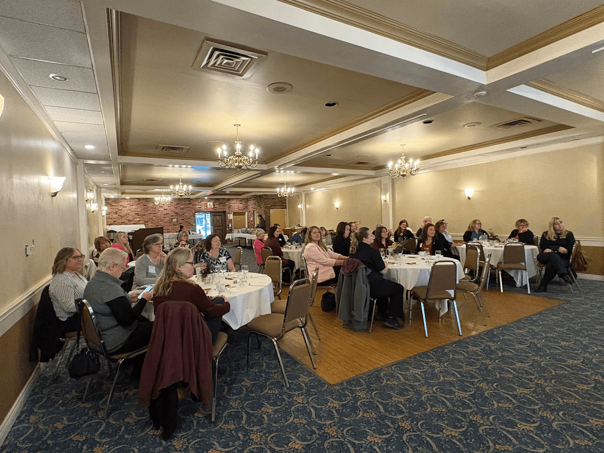 Guests seated at round tables in the banquet hall